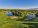 Scenic golf course view showcasing lush green fairways, a serene pond, and mature trees at 5698 Hoptree Dr # 1, Pahrump, NV 89061