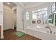 Bright bathroom featuring a separate tub and shower, wood floors, and a window for natural light at 5698 Hoptree Dr # 1, Pahrump, NV 89061