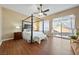 Bright main bedroom featuring wood floors, a ceiling fan, and a sliding glass door to the backyard at 5698 Hoptree Dr # 1, Pahrump, NV 89061