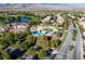 Aerial view of a community pool area with palm trees, lounge chairs, and well-maintained landscaping at 5698 Hoptree Dr # 1, Pahrump, NV 89061