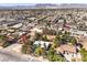 Expansive aerial view of a residential area with a charming white-roofed house surrounded by lush trees and greenery at 5715 Gilbert Ln, Las Vegas, NV 89130