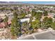 A serene aerial view showcases a residential property nestled amidst lush greenery and trees. Mountains in the background at 5715 Gilbert Ln, Las Vegas, NV 89130