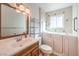 Well-lit bathroom features a single sink vanity, toilet, and a walk-in bathtub for safety and relaxation at 5715 Gilbert Ln, Las Vegas, NV 89130