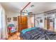 Spacious main bedroom featuring a four-poster bed, Saltillo tile floors, and bright natural light at 5715 Gilbert Ln, Las Vegas, NV 89130