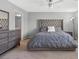 Modern bedroom featuring a gray color scheme, including a large, tufted headboard and matching dresser at 5971 Sonoma Station Ave, Las Vegas, NV 89139