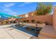 Backyard view of a sparkling swimming pool with water feature, stylish tiling, and manicured landscaping at 5971 Sonoma Station Ave, Las Vegas, NV 89139