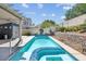 Inviting pool with an attached spa and meticulously maintained landscaping and hardscaping with lush greenery and beautiful skies at 6109 Flaming Arrow Rd, North Las Vegas, NV 89031