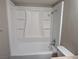 Full white shower-tub in the bathroom with toiletry storage, great lighting and beige walls at 615 S Royal Crest Cir # 15, Las Vegas, NV 89169