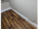 Close-up of the dark wood laminate flooring and white baseboards in this neutrally painted bedroom at 615 S Royal Crest Cir # 15, Las Vegas, NV 89169