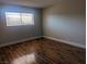 Cozy bedroom with a large window offering natural light and beautiful dark laminate wood flooring at 615 S Royal Crest Cir # 15, Las Vegas, NV 89169