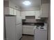 A compact kitchen featuring white appliances and cabinets at 615 S Royal Crest Cir # 15, Las Vegas, NV 89169