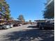 View of the apartment complex parking area with covered parking spaces, trees, and clear skies at 615 S Royal Crest Cir # 15, Las Vegas, NV 89169