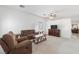 Comfortable living room featuring carpet flooring, a ceiling fan, and easy access to other living areas at 6314 Ruby Cedar Ct, North Las Vegas, NV 89031