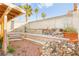 Spacious backyard with tiered landscaping, rock features, and tall privacy walls at 6653 Lund Dr, Las Vegas, NV 89108