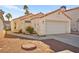 Charming single-story home featuring a two-car garage, desert landscaping, and a red tile roof at 6653 Lund Dr, Las Vegas, NV 89108