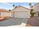 Charming single-story home featuring a two-car garage, desert landscaping, and a red tile roof at 6653 Lund Dr, Las Vegas, NV 89108