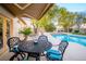 Inviting outdoor patio with comfortable seating, shade awning, and a view of the pool and lush landscaping at 692 Quilt Pl, Henderson, NV 89052