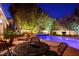 Night view of the backyard's inviting pool and spa with lounge chairs set on the pool deck at 692 Quilt Pl, Henderson, NV 89052