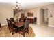 Formal dining room with chandelier, wood table, and arched doorway at 692 Quilt Pl, Henderson, NV 89052