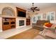 Relaxing living room featuring built-in shelves, fireplace, and a ceiling fan at 692 Quilt Pl, Henderson, NV 89052