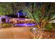 A stunning backyard at night showcasing a sparkling pool, mature trees, and an inviting outdoor living space at 692 Quilt Pl, Henderson, NV 89052