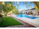 Inviting backyard pool and spa, with a charming pergola and lush landscaping, perfect for outdoor relaxation and entertaining at 692 Quilt Pl, Henderson, NV 89052