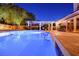 Tranquil backyard pool at night, illuminated by soft lighting, creates a serene and inviting atmosphere for evening relaxation at 692 Quilt Pl, Henderson, NV 89052