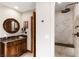 Elegant bathroom with wood vanity, marble countertop, and tiled shower with seat, offering a spa-like experience at 7229 Mira Vista St, Las Vegas, NV 89120