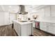 Well-designed kitchen with white cabinets, a stainless steel range hood, and a large island with seating at 7229 Mira Vista St, Las Vegas, NV 89120