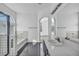 Bright bathroom featuring a double sink vanity and a glass-enclosed tub shower at 7308 Alpine Ridge St, Las Vegas, NV 89131