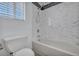 Beautifully remodeled bathroom showcasing white marble-style tile and modern shower fixture over tub at 7308 Alpine Ridge St, Las Vegas, NV 89131