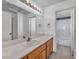 Bathroom vanity with large mirror, updated lighting, and a view of the tiled shower and tub at 7308 Alpine Ridge St, Las Vegas, NV 89131