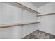 Spacious walk-in closet with multiple shelves and wooden rods for ample storage space at 7308 Alpine Ridge St, Las Vegas, NV 89131