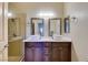 Bathroom with double vessel sinks, dark cabinets, and glass enclosed shower at 8301 Boseck Dr # 215, Las Vegas, NV 89145