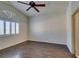 Bedroom with wood floors, ceiling fan, and large window with stylish white shutters at 8301 Boseck Dr # 215, Las Vegas, NV 89145