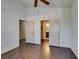 Bedroom with dark wood-look floors, ceiling fan, and access to closets and an ensuite bathroom at 8301 Boseck Dr # 215, Las Vegas, NV 89145