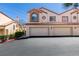 Delightful townhome featuring a two-car garage, desert landscaping, and charming architectural details at 8301 Boseck Dr # 215, Las Vegas, NV 89145
