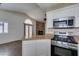 Open kitchen area with stainless steel appliances, gas range, and granite countertops, with a view of a fireplace at 8301 Boseck Dr # 215, Las Vegas, NV 89145