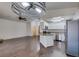 Spacious living room with wood floors connected to an open kitchen with stainless steel appliances and granite counters at 8301 Boseck Dr # 215, Las Vegas, NV 89145