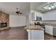 Open-concept living area with a stone fireplace flowing into a kitchen with stainless steel appliances and granite counters at 8301 Boseck Dr # 215, Las Vegas, NV 89145