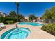 Community pool and hot tub surrounded by lush landscaping and lounge chairs at 8301 Boseck Dr # 215, Las Vegas, NV 89145
