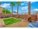 Cozy backyard featuring a small lawn, desert landscaping, and palm trees for a relaxing outdoor space at 8349 Spruce Bay Ave, Las Vegas, NV 89178