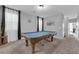 Spacious game room featuring a blue felt pool table, neutral carpet, gray walls, and bright natural light at 8349 Spruce Bay Ave, Las Vegas, NV 89178