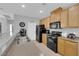 Galley kitchen features light wood cabinets and black appliances at 8349 Spruce Bay Ave, Las Vegas, NV 89178