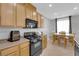 Eat-in kitchen includes light wood cabinets and black appliances at 8349 Spruce Bay Ave, Las Vegas, NV 89178