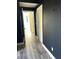 Hallway with gray wood-style flooring and dark blue accent wall leading to other rooms of the home at 9050 W Warm Springs Rd # 2016, Las Vegas, NV 89148