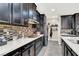 Modern kitchen featuring sleek black cabinets, stainless steel appliances, and stylish backsplash at 920 Claystone Ridge Ave, North Las Vegas, NV 89084