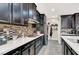 A galley style kitchen with white countertops and stainless appliances at 920 Claystone Ridge Ave, North Las Vegas, NV 89084