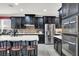 Well-equipped kitchen featuring dark cabinets, stainless steel appliances, and a center island with bar seating at 920 Claystone Ridge Ave, North Las Vegas, NV 89084