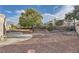 Spacious backyard showcasing gravel landscaping, mature trees, and a concrete patio area at 9421 Gold Mountain Dr, Las Vegas, NV 89134